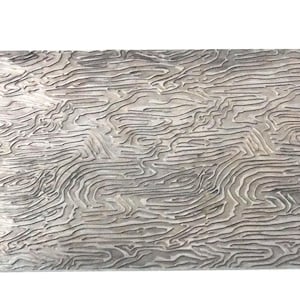 May include: A rectangular, textured, silver-toned decorative panel. The surface features a detailed, organic pattern of swirling, linear grooves, resembling a topographical map or wood grain. The panel is likely used for home decor.
