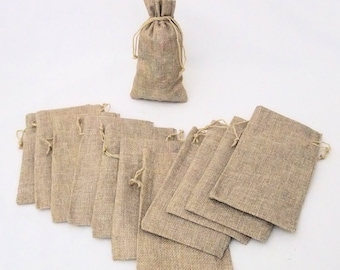 May include: A set of 15 small burlap drawstring bags. The bags are a light brown color and are made of natural burlap fabric. The bags are perfect for packaging small gifts or favors.
