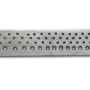 Può includere: Un righello in metallo argentato con una serie di fori di diverse dimensioni. Il righello è etichettato "82°" e "MONO POLY."