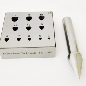 May include: A silver metal block with 14 round holes in a grid pattern, labeled 4 to 14 mm. The block is labeled "Trillion Bezel Block Small - 4 to 14MM". A silver metal tool with a pointed tip is next to the block.