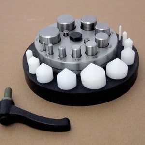 May include: A metal circle punch set with a variety of sizes, including 1/8", 1/4", 3/8", 1/2", and 5/8". The set also includes a black handle and a set of white plastic punches.