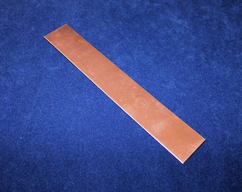 May include: A thin, rectangular sheet of copper metal. The copper has a slightly reddish-brown color and a smooth, polished surface.