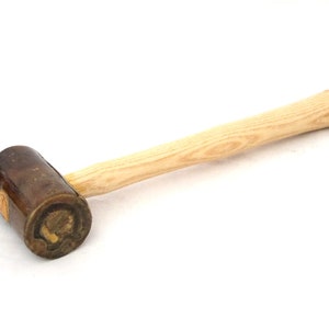 May include: A wooden mallet with a brown leather head. The handle is made of light wood and has a natural grain.