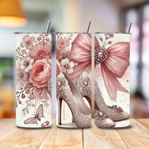Peut inclure: Trois gobelets en acier inoxydable avec un motif floral rose, un nœud rose et une paire de chaussures à talons hauts roses avec des détails en dentelle.