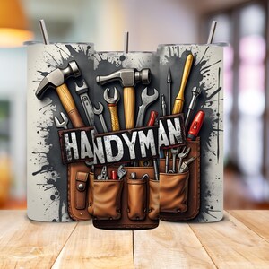 May include: A white tumbler with a graphic of a tool belt with various tools, including hammers, screwdrivers, and wrenches. The text "HANDYMAN" is printed on the tool belt.
