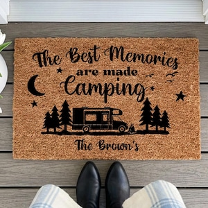 May include: A rectangular coir doormat with the text "The Best Memories are made Camping" in black script. A black camper illustration is centered below the text, with trees and stars. The bottom text reads "The Brown's".