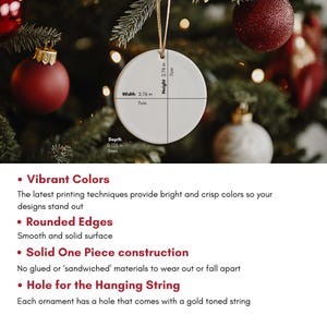May include: A round, white Christmas ornament with a gold string, 7 cm in width and height, and 3 mm in depth. The ornament is displayed on a Christmas tree with red and gold baubles.