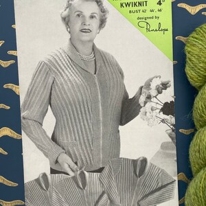 May include: A knitting pattern for a cardigan, called "Kiddie Kwiknit", designed by Penelope. The pattern is for a size 42, 44, or 46 inch bust. The pattern is from 1950s and features a woman wearing the cardigan.