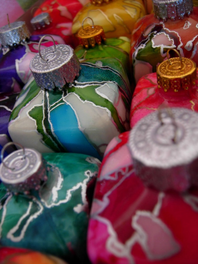 May include: A collection of colorful glass ornaments with intricate designs. The ornaments are decorated with various colors, including green, blue, red, and white. The ornaments are perfect for adding a touch of whimsy to any Christmas tree.