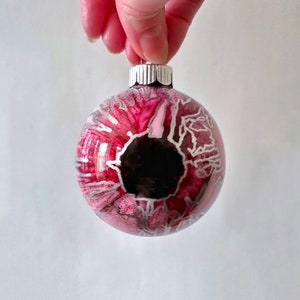 This hand-painted ornament, resembling a bloodshot eyeball, would be a unique and macabre addition to your holiday decor. Each ornament is a unique piece and cannot be duplicated. Created by Sarah John Afana for schemata on Etsy.
