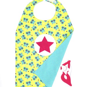 May include: A yellow cape with a butterfly pattern and a red star on the front. The cape is reversible and has a blue polka dot pattern on the other side. It comes with a red felt mask with a white star.