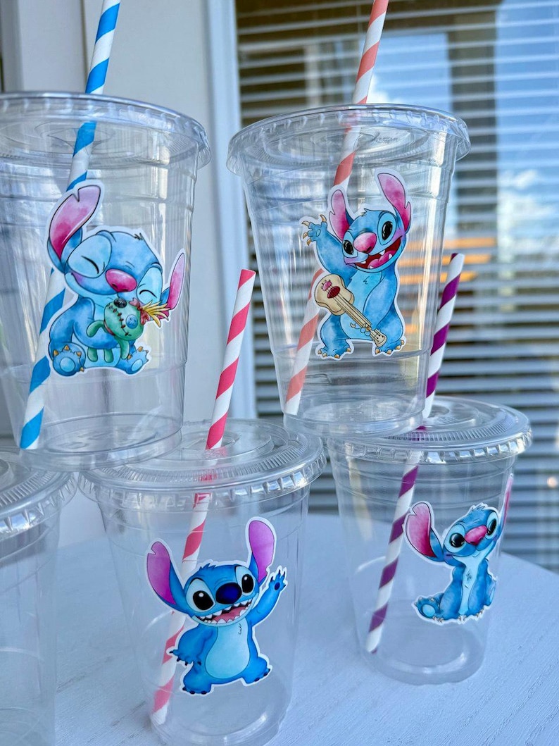 May include: Clear plastic cups with blue and white Stitch character stickers. The cups have colorful striped straws.