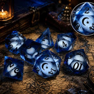 May include: A set of polyhedral dice made of translucent blue resin with white spherical inclusions inside. Each die features black engraved numbers, with a crescent moon and star symbol replacing the highest value on each die face.