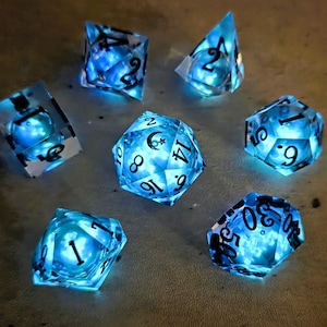 Conjunto básico de dados líquidos que brillan en la oscuridad Lunar Wave (azul): Dados D&D de borde afilado