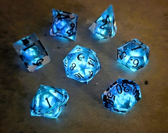 Conjunto básico de dados líquidos que brillan en la oscuridad Lunar Wave (azul): Dados D&D de borde afilado