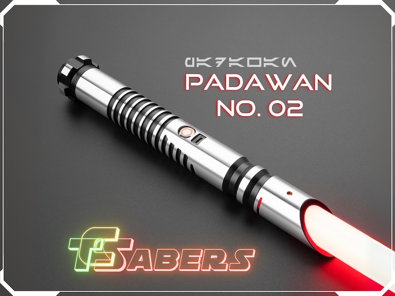 Puede incluir: Un sable de luz plateado y negro con una hoja roja brillante. El texto "PADAWAN NO. 02" se muestra en rojo. El logotipo "FSABERS" es verde y naranja.