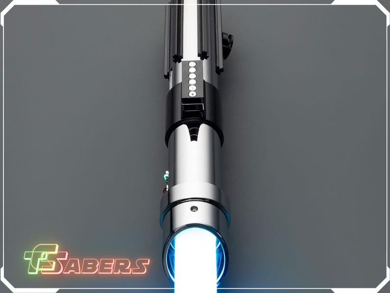 May include: A silver and black lightsaber with a bright white blade emanating from the hilt. The hilt features a black grip, silver accents, and a series of illuminated buttons. The logo "FSABERS" is visible in the lower left corner.