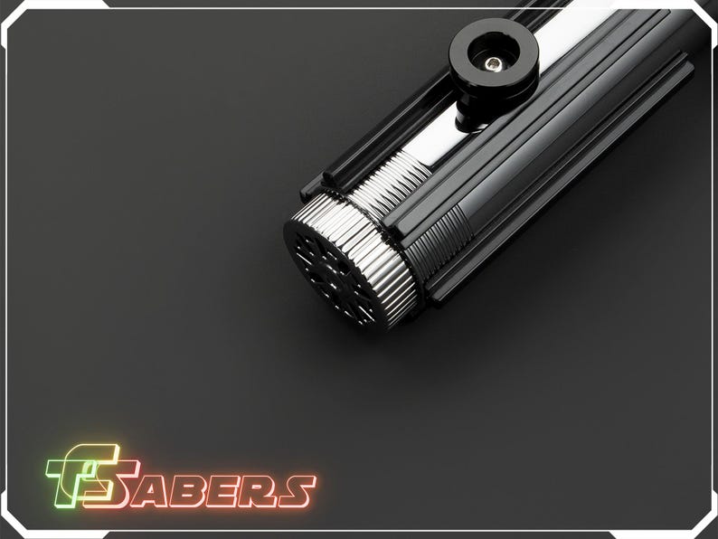 May include: A black and silver lightsaber with a ribbed handle and a circular emitter. The lightsaber has a glossy finish and a black accent piece near the top. The logo "TSABERS" is displayed in neon colors.