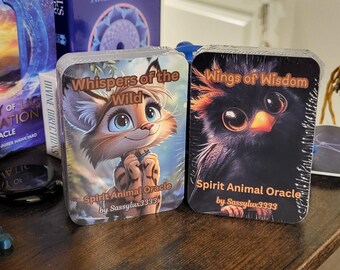 May include: Two oracle cards with colorful illustrations of a lynx and an owl. The cards are titled "Whispers of the Wild" and "Wings of Wisdom". Both cards feature the text "Spirit Animal Oracle by Sassylux3333".