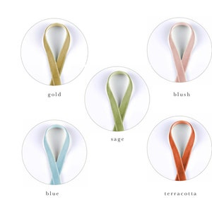 May include: Five different colors of velvet ribbon, displayed in circles on a white background. The colors are gold, blush, sage, blue, and terracotta.