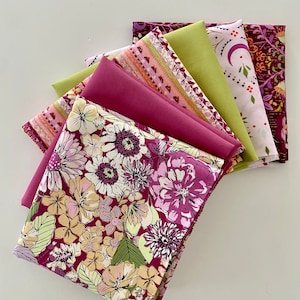May include: A stack of six fabric squares in various floral and geometric patterns. The fabrics are in shades of pink, green, and brown.