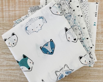 May include: A set of five fabric squares featuring a variety of animal illustrations in black and blue on a white background. The animals include a fox, a raccoon, a badger, a hedgehog, and a polar bear.