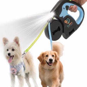Può includere: Un guinzaglio retrattile nero e blu per cani con torcia integrata e dispenser per sacchetti per rifiuti. Il guinzaglio è attaccato a due cani, uno bianco e uno dorato, entrambi con imbracature. L'impugnatura riporta la scritta "ZUPET Pet Life Imagine".