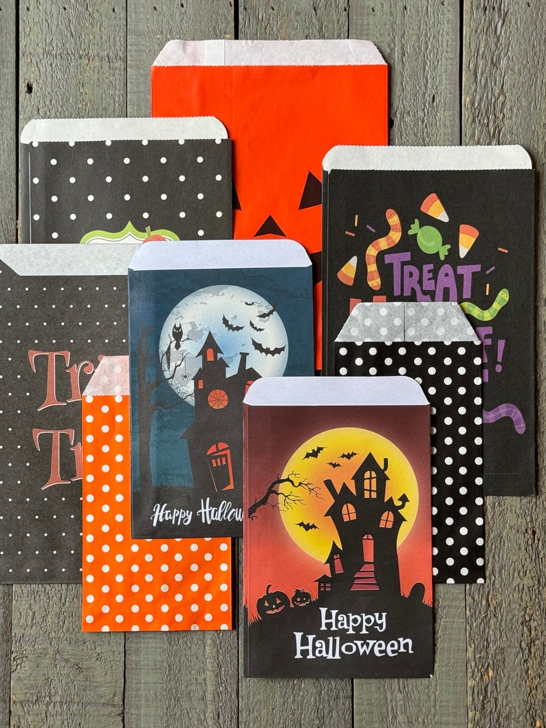 Pu&ograve; includere: Un set di otto sacchetti per dolcetti di Halloween con vari design. I sacchetti presentano pois neri e bianchi, pois arancioni e bianchi, un design bianco e nero con un motivo di mais dolce e vermi, un design bianco e nero con il testo "Treat", un design blu con una luna, una casa e pipistrelli, e un design rosso con una luna, una casa e pipistrelli. Tutti i sacchetti hanno il testo "Happy Halloween" su di loro.