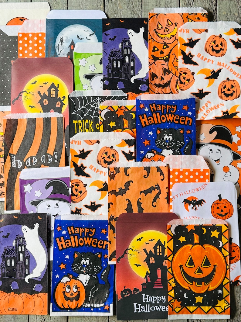 Pu&ograve; includere: Una collezione di sacchetti di carta a tema Halloween con vari disegni, tra cui zucche, fantasmi, pipistrelli e gatti. I sacchetti riportano il testo "Happy Halloween" e "Trick or Treat".