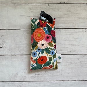 May include: A floral patterned fabric sunglasses case with a pair of black sunglasses inside.