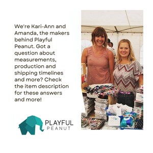 May include: Two women stand behind a table displaying colourful fabric items. The table is covered with a white tablecloth. The women are smiling and looking at the camera. The text "We're Kari-Ann and Amanda, the makers behind Playful Peanut. Got a question about measurements, production and shipping timelines and more? Check the item description for these answers and more!" is visible in the image. The text "PLAYFUL PEANUT" is also visible in the image.
