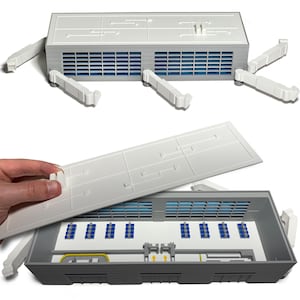 May include: A white and gray model of a building with blue accents. The model has a removable roof, revealing the interior with blue and yellow details. Several white ventilation ducts are attached to the building.