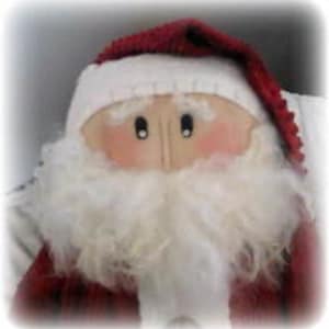Puede incluir: Primer plano de una muñeca de Papá Noel con un gorro rojo y blanco y una barba blanca y esponjosa. La muñeca tiene mejillas rosadas y ojos negros. La muñeca de Papá Noel es una decoración festiva.