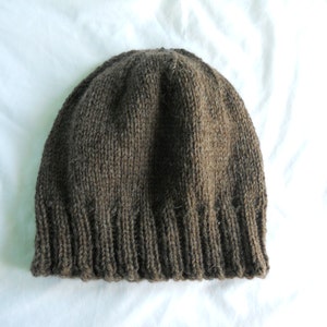 May include: A brown knitted beanie hat with a ribbed brim.