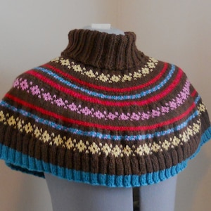 May include: A brown knitted turtleneck collar with a colorful geometric pattern in shades of red, pink, yellow, and blue.