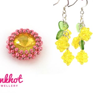 May include: A pair of earrings featuring a yellow and green crystal design. The earrings are crafted with silver wire and showcase a cluster of yellow crystals with green accents. The earrings are suspended from silver hooks.