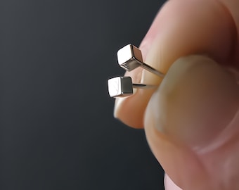 Op de afbeelding: Een paar zilveren vierkante oorbel studs. De oorbellen zijn klein en eenvoudig en perfect voor dagelijks gebruik.