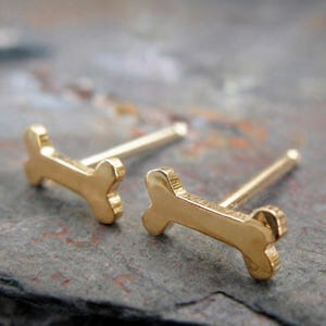 Puede incluir: Un juego de tres tazas de cerámica con un acabado mate moteado. Las tazas son de color crema, gris claro y gris oscuro. Cada taza tiene un diseño minimalista, para café o té.