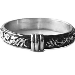 May include: A silver ring with an ornate, floral design. The ring features a dark, oxidized finish on the outer band, with a detailed pattern of swirling leaves and flowers. The ring has a unique, raised section with three vertical bars.