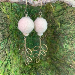 May include: A pair of white felt ball earrings with delicate bronze leaf branch dangles.