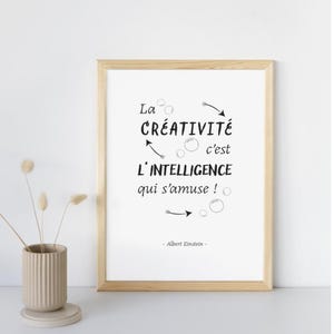 Op de afbeelding: Een ingelijst print met een witte achtergrond en zwarte tekst die "La créativité c'est l'intelligence qui s'amuse!" - Albert Einstein luidt.
