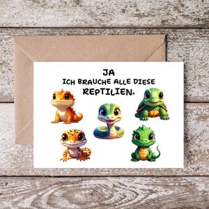 Könnte beinhalten: Eine Grußkarte mit Cartoon-Reptilien, darunter eine Eidechse, eine Schlange und eine Schildkröte. Der Text auf der Karte lautet "JA ICH BRAUCHE ALLE DIESE REPTILIEN."