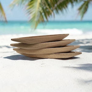 Puede incluir: Una pila de cuatro bandejas de madera alargadas en forma de barco con un acabado liso de veta de madera natural marrón claro. Cada bandeja presenta un interior poco profundo y cóncavo con extremos cónicos, creando un aspecto uniforme.