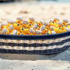 May include: A woven basket with alternating navy blue and white horizontal stripes filled with numerous yellow rubber ducks. Each duck wears a white sailor hat with a small blue anchor emblem and a navy blue neckerchief around its neck.