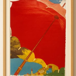 May include: Vintage travel poster in a wooden frame. The poster features a large red shape, possibly a sun or umbrella, with a long yellow pole. Text at the bottom reads "LES GRISONS SUISSE PAYS DU SOLEIL". The artwork has a retro style.