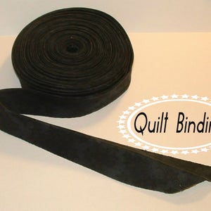 May include: Black quilt binding, a continuous strip of fabric used to finish the edges of a quilt.