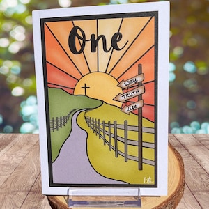 May include: A greeting card featuring a vibrant illustration. The word "One" is displayed above a sunset scene with a cross and a road. Arrows point to "way", "truth", and "life".
