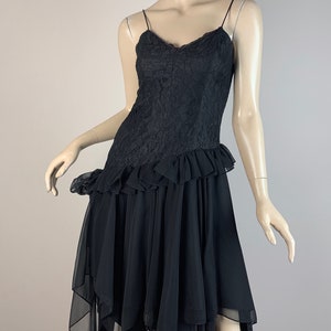 May include: A black lace and chiffon dress with a ruffled hem and a layered, asymmetrical skirt.