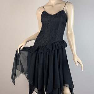 May include: A black lace and chiffon dress with a ruffled hem and a layered, asymmetrical skirt.