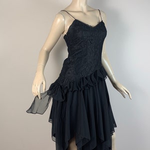 May include: A black lace and chiffon dress with a ruffled skirt and a sweetheart neckline.